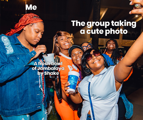 A meme of several women taking photos, while one enjoys some Jambalaya, not caring about taking a group pic.